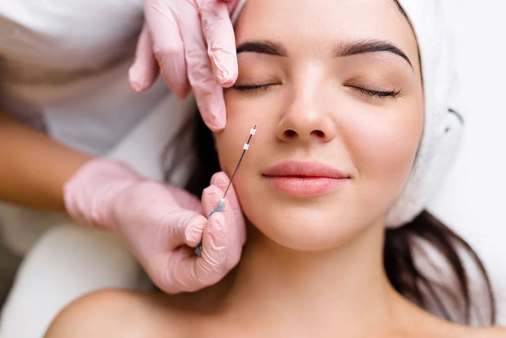 Woman receiving cosmetic facial injection treatment.